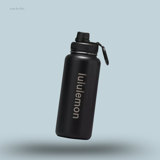 Lululemon Back to Life Sport Bottle 32oz in black, flat lay on light blue background