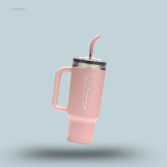 Lululemon Back to Life Tumbler 24oz in peach with handle and straw lid, on light blue background