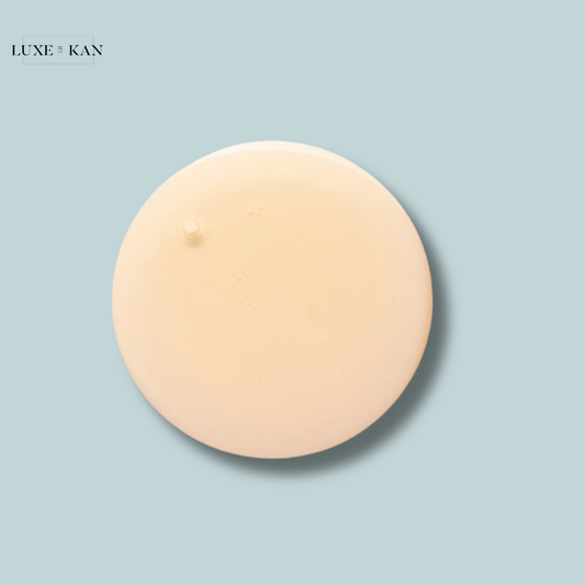 A smooth, creamy, beige skincare product in a circular shape against a light blue background, labeled "Luxe & Kan."