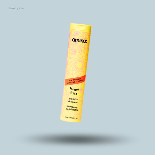 Amika Forget Frizz anti-frizz shampoo bottle in yellow packaging with pink pattern and text.