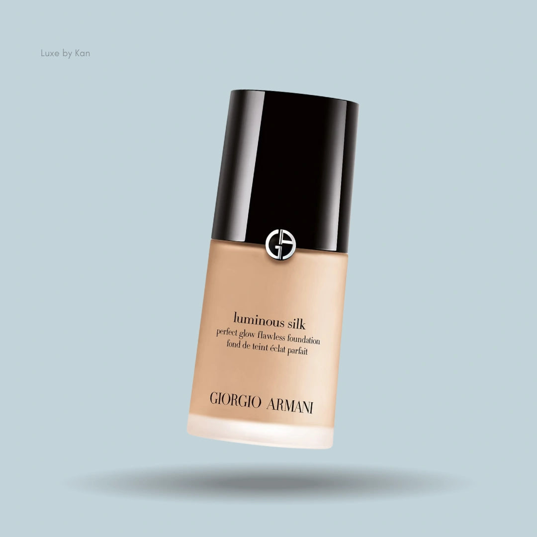 Armani Luminous Silk foundation bottle with black cap on blue background.