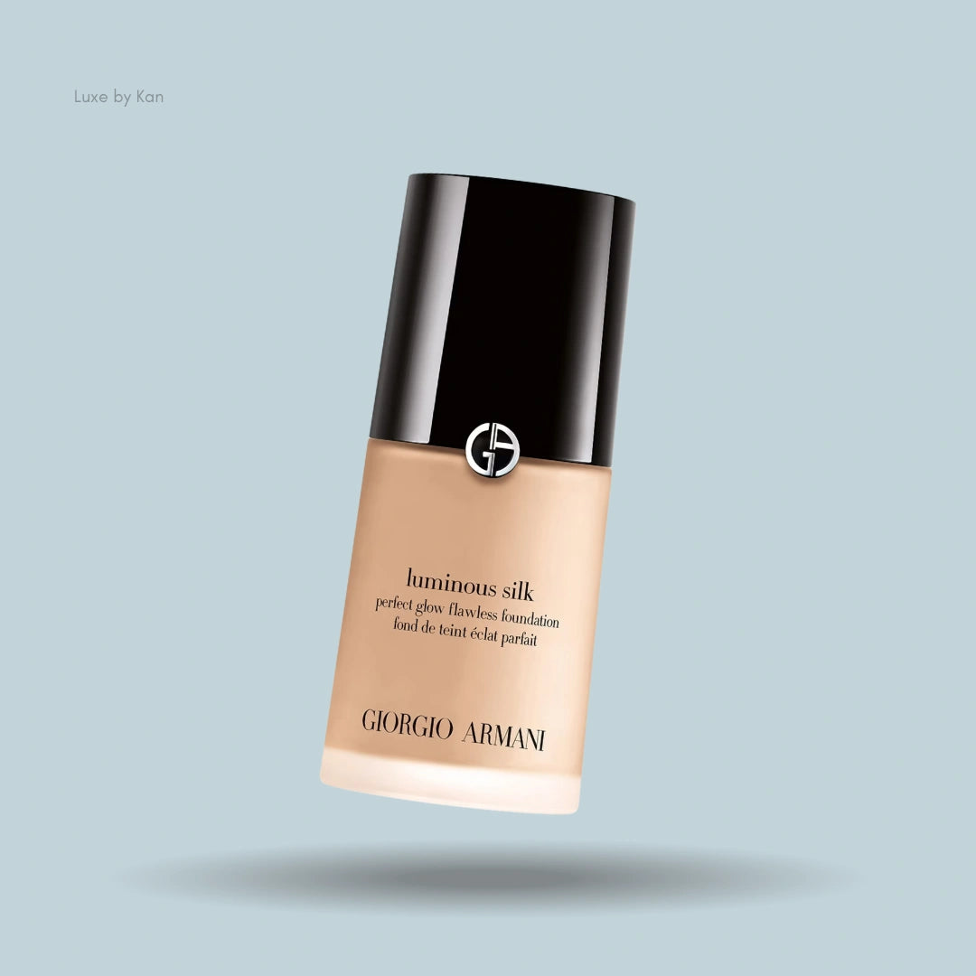 Armani Luminous Silk foundation bottle with black cap on light blue background.