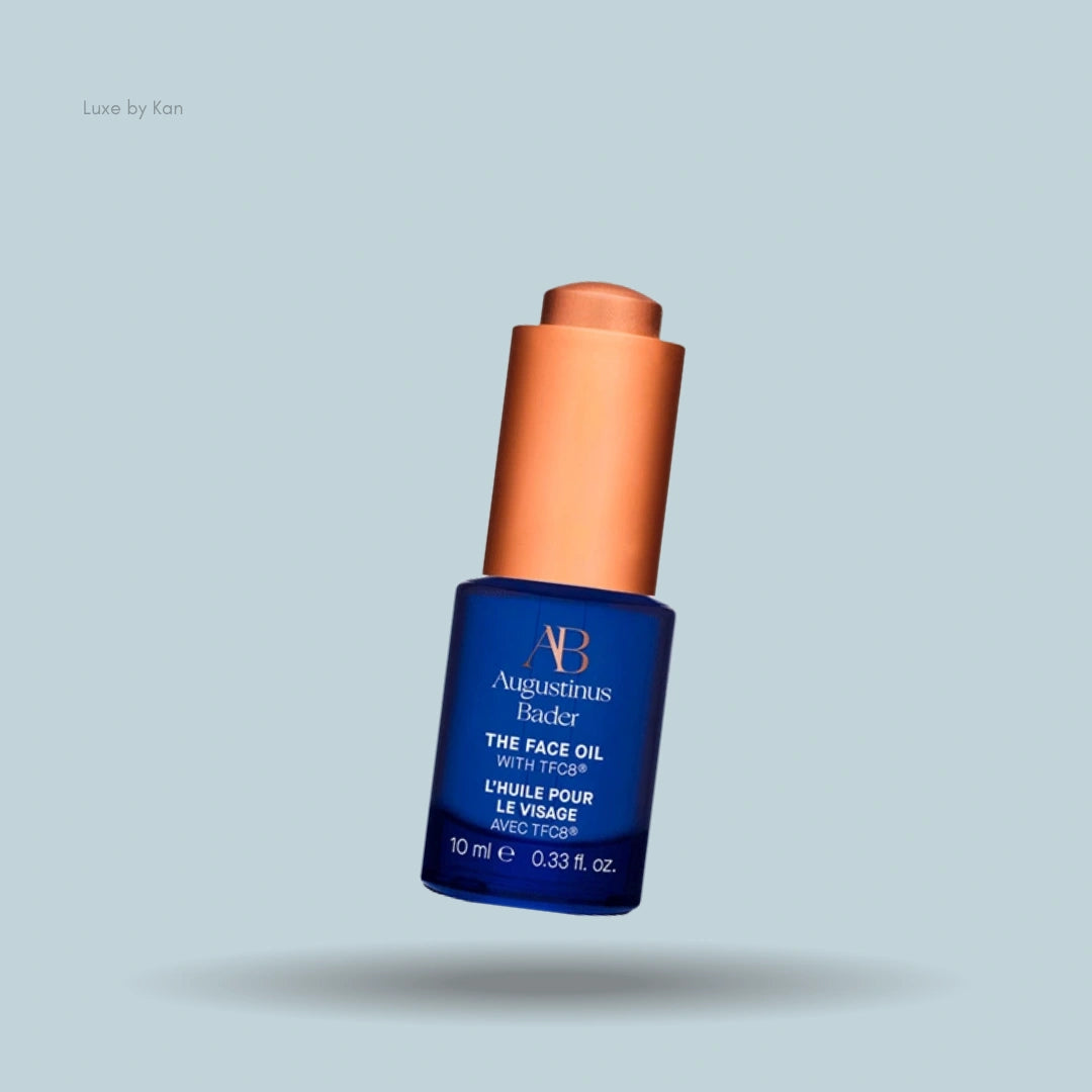 A tilted bottle of Augustinus Bader The Face Oil with its dropper.