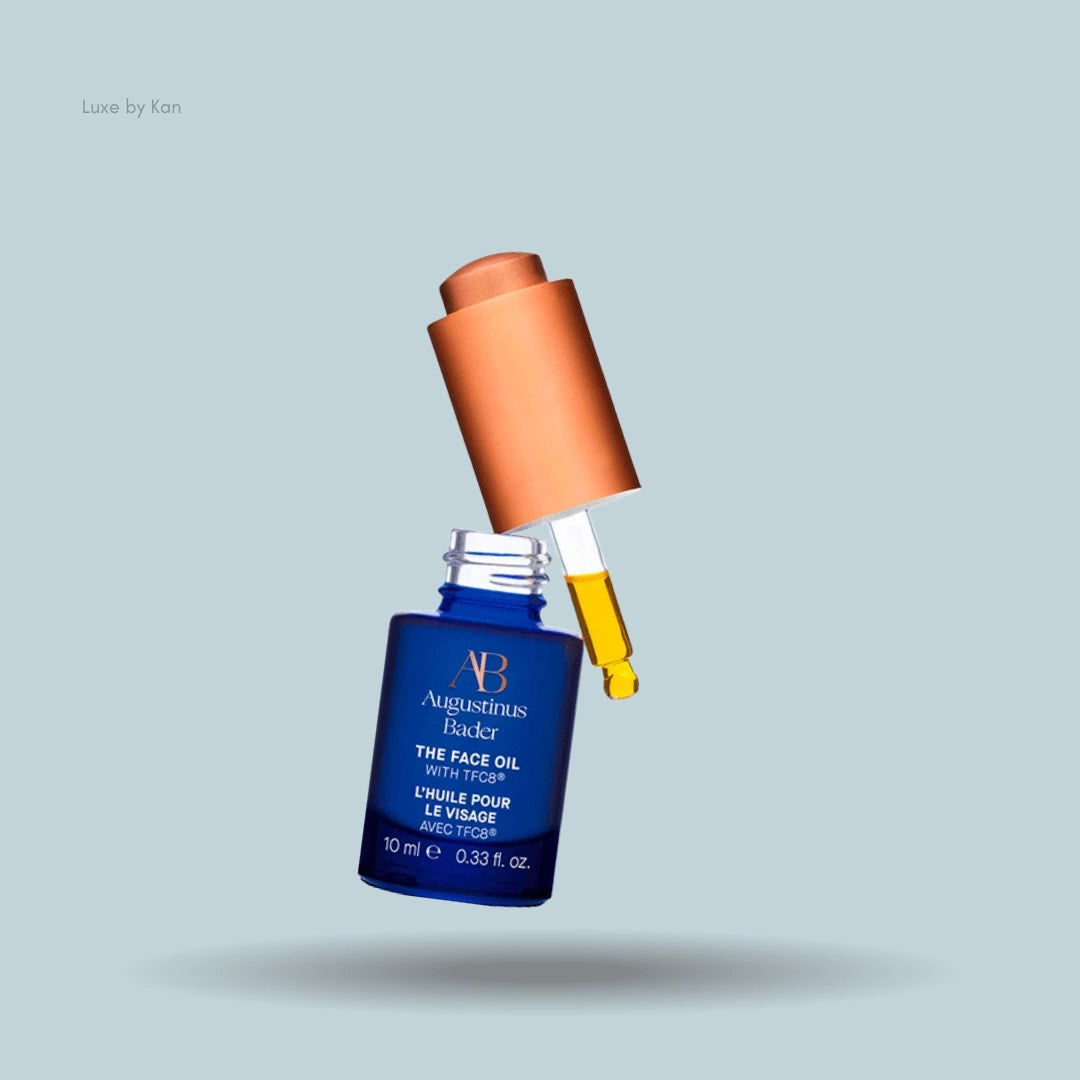Augustinus Bader The Face Oil in a blue bottle with a copper-colored dropper.