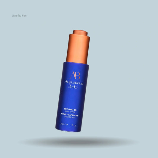 Augustinus Bader Hair Oil with TFC8 in a sleek blue bottle with a copper cap.
