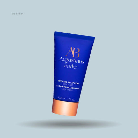 Augustinus Bader the hand treatment in a blue tube with an apricot-colored cap.