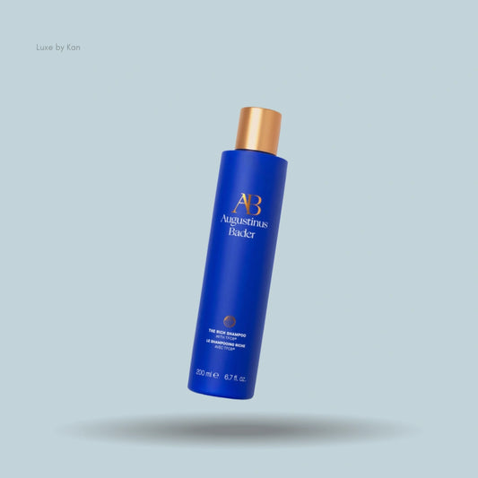 Blue Augustinus Bader "The Rich Shampoo" bottle with gold cap.