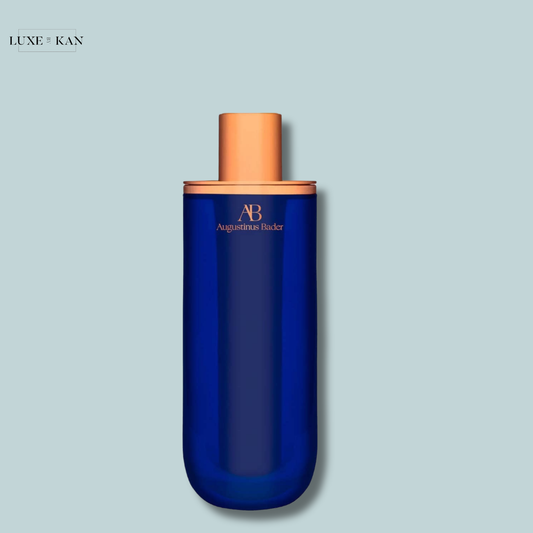 Augustinus Bader The Serum in a blue glass bottle with gold accents and the brand logo prominently displayed.