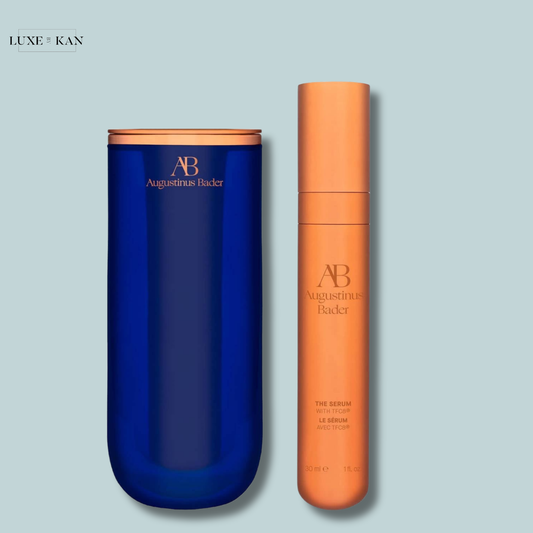 Augustinus Bader "The Serum" in a tall orange bottle placed beside a short dark blue container.
