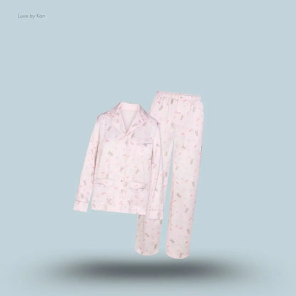 SKIMS Woven Shine Long Sleep Set in Barely Pink Snack Bag, flat lay on light blue background