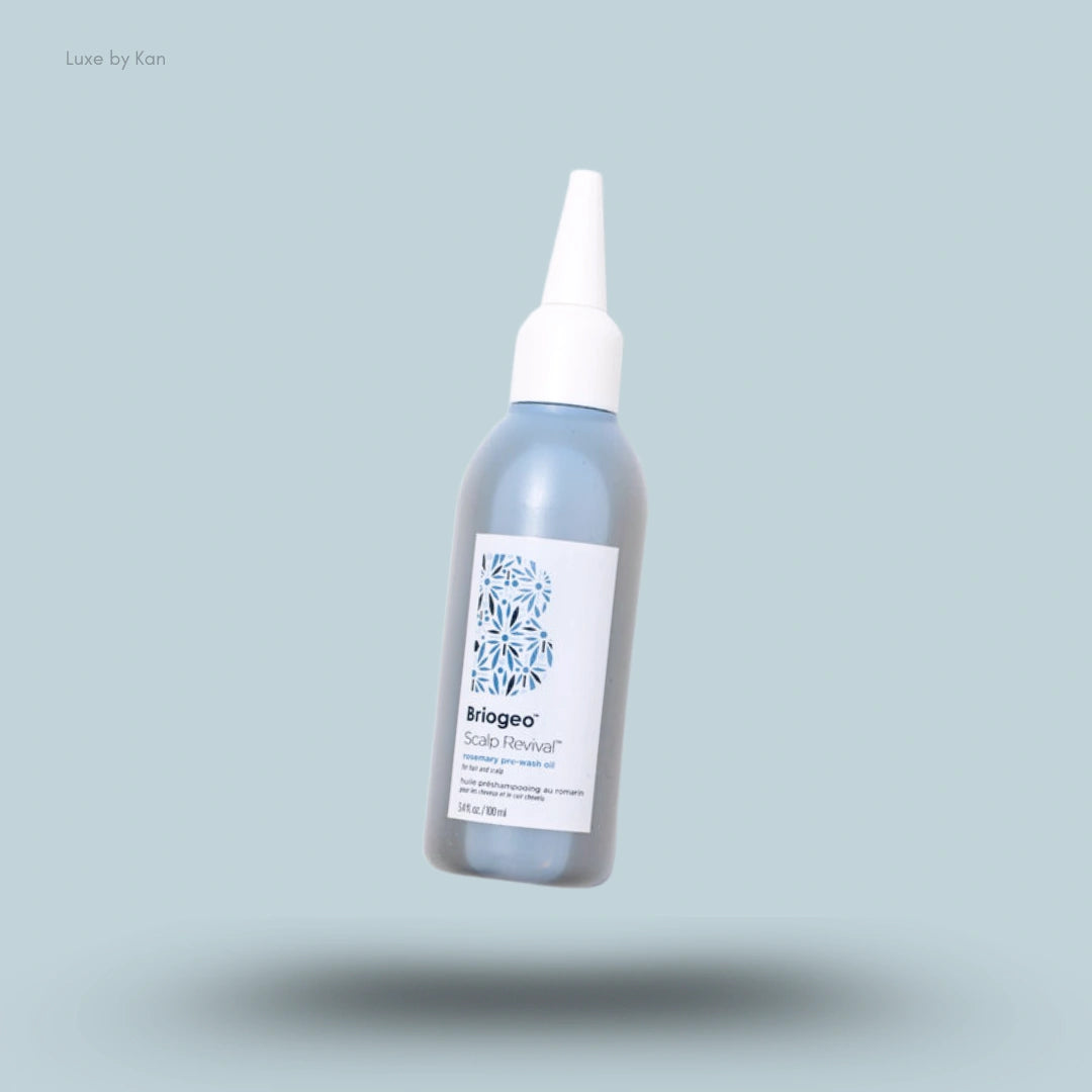 A bottle of Briogeo Scalp Revival™ Rosemary Pre-Wash Oil in a blue bottle with a white applicator cap.