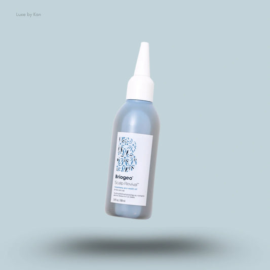 A bottle of Briogeo Scalp Revival™ Rosemary Pre-Wash Oil in a blue bottle with a white applicator cap.