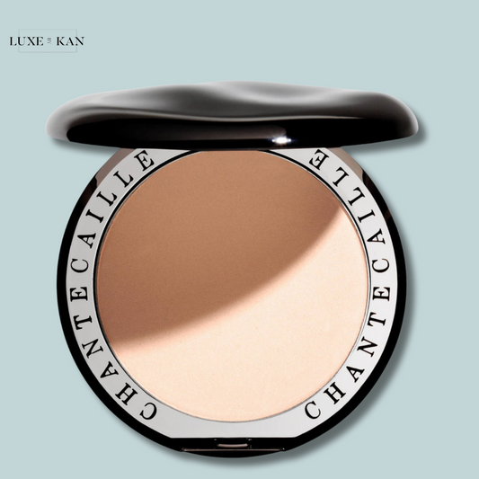 Chantecaille HD Perfecting Powder compact with an open lid, revealing the face powder on a light blue background.