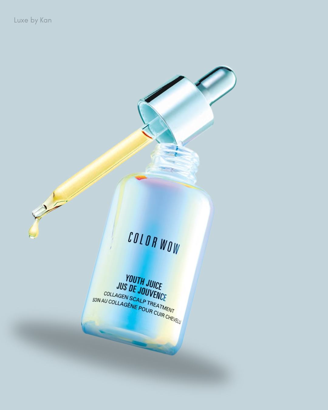 A dropper bottle of Color Wow Youth Juice collagen scalp treatment, with a golden serum dripping from the pipette.