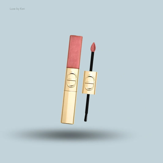 A DIOR Rouge Dior Limited Edition Sequin Liquid Duo lip gloss tube and applicator with gold packaging on a blue background.