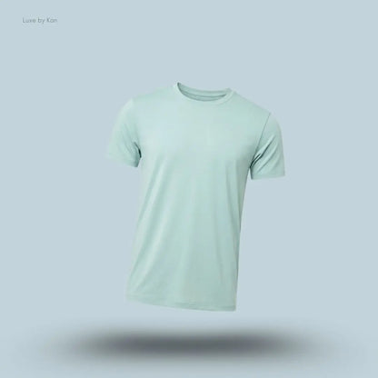 Alo Conquer Reform Crewneck Short Sleeve in Desert Sage, flat lay on light blue background
