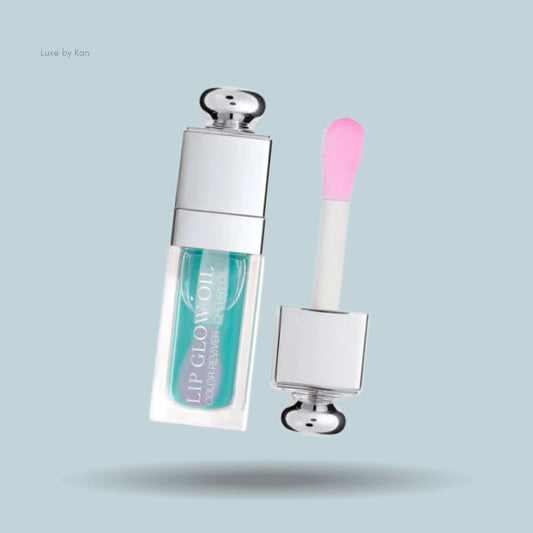 Dior Addict Lip Glow Oil featuring a vibrant turquoise tint, housed in a sleek clear tube with a soft pink applicator for smooth, glossy application.