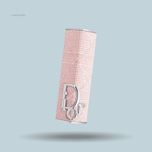 Close-up of a pale pink Dior Addict lipstick case, decorated with a quilted pattern and silver "Dior" logo.