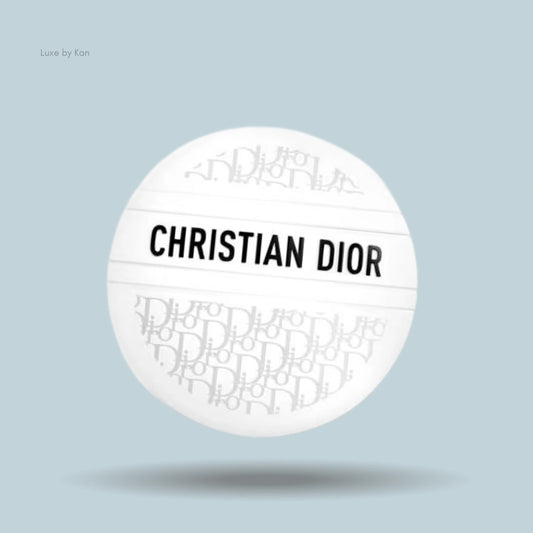 A white, spherical Dior balm container with "CHRISTIAN DIOR" printed horizontally across the center.