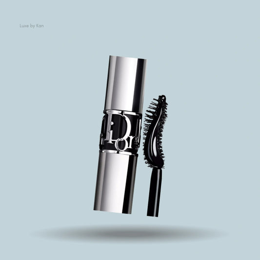 Close-up of Diorshow volume and curl mascara, showing the silver tube with Dior logo and curved wand.