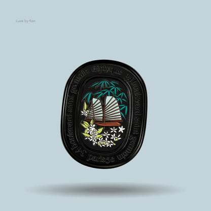 Diptyque Do Son refillable solid perfume compact, featuring sailing boat with bamboo and white flowers in a black oval compact.