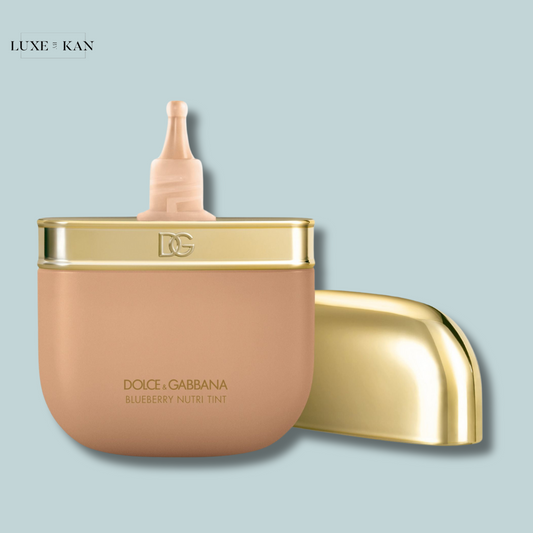 A stylish container of Dolce & Gabbana Blueberry Nutri Tint foundation, featuring a gold lid and a sleek design.