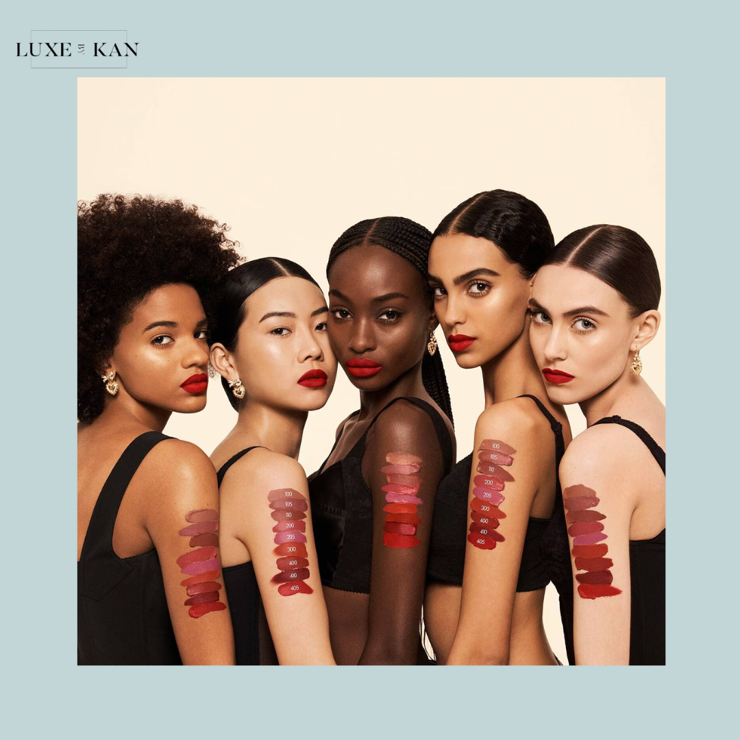 Five women showcase a range of lipstick swatches on their arms, featuring various shades of red and pink.