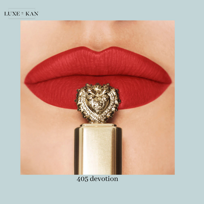 Close-up of bold red lips adorned with a luxurious lipstick featuring a decorative gold lion and heart design, labeled "405 Devotion."