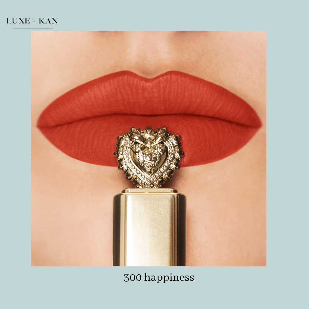 Close-up of bold red lips adorned with a luxurious lipstick featuring an ornate gold heart-shaped cap, labeled "300 happiness."