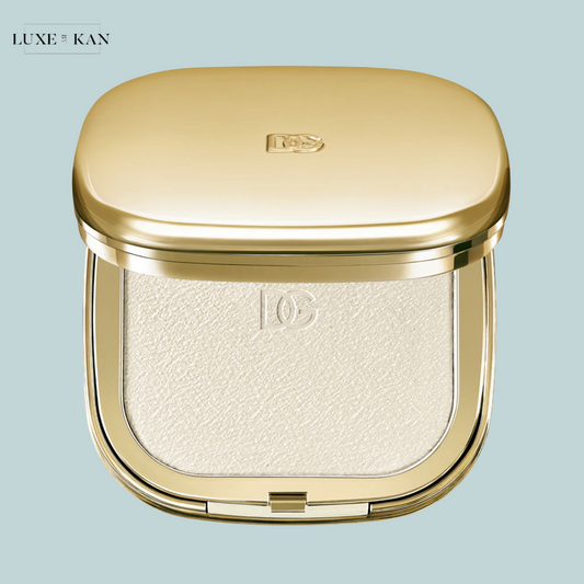 A luxurious golden dolce & gabbana fresh fig skin perfector finishing powder featuring a smooth, shimmering powder inside.