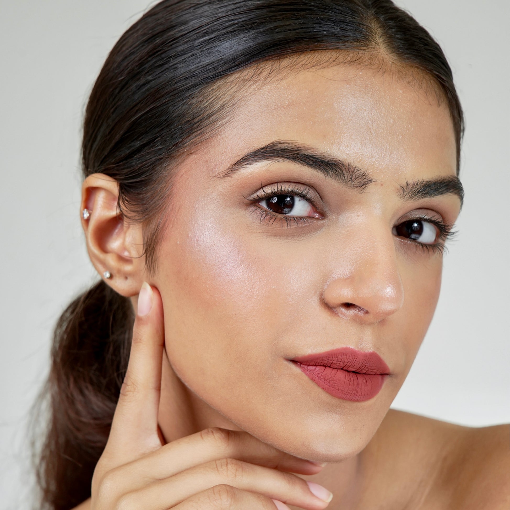 A woman face close-up with era beauty velvet liquid matte lipstick in shade lover girl.