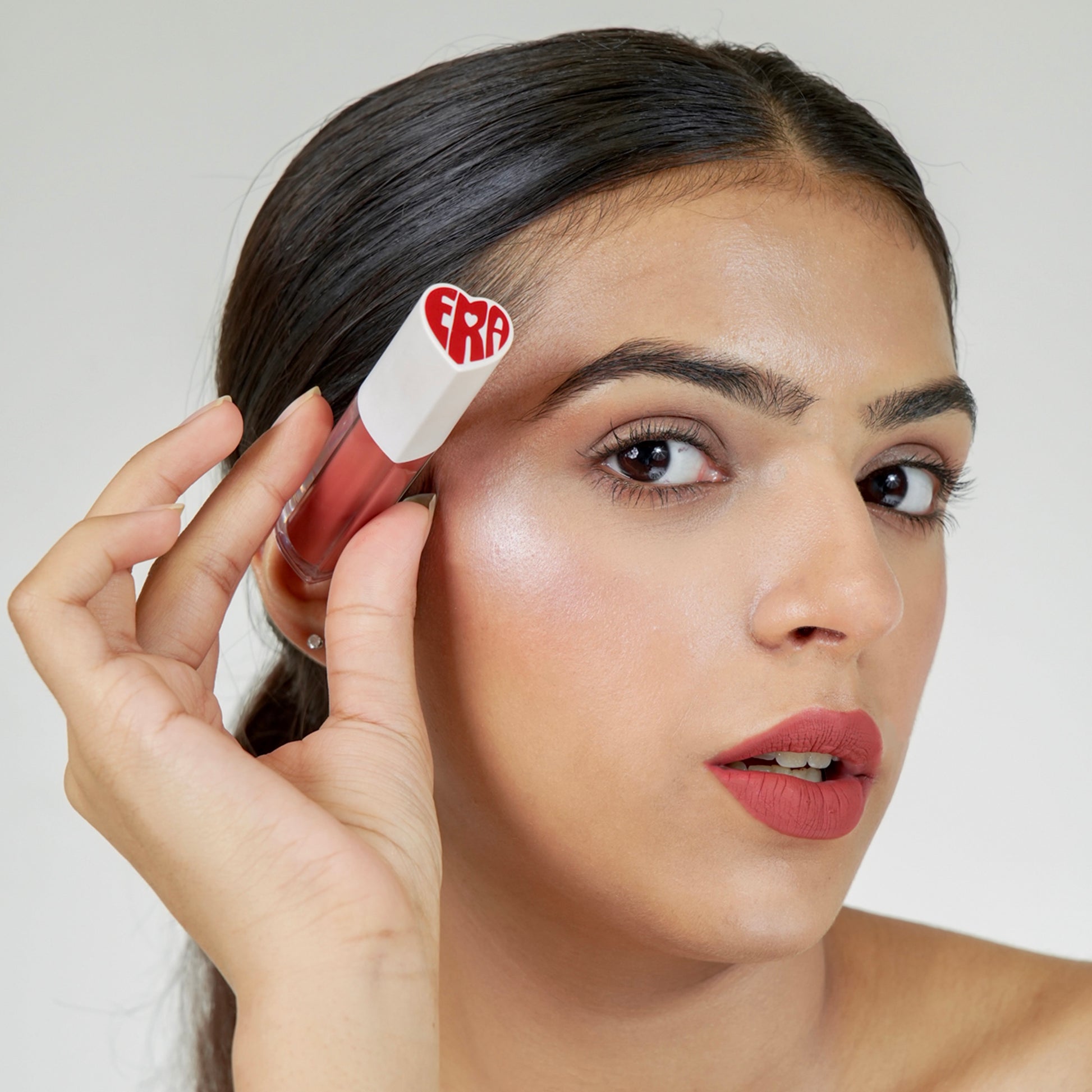 A person holds a Era beauty lover girl shade lipstick product.