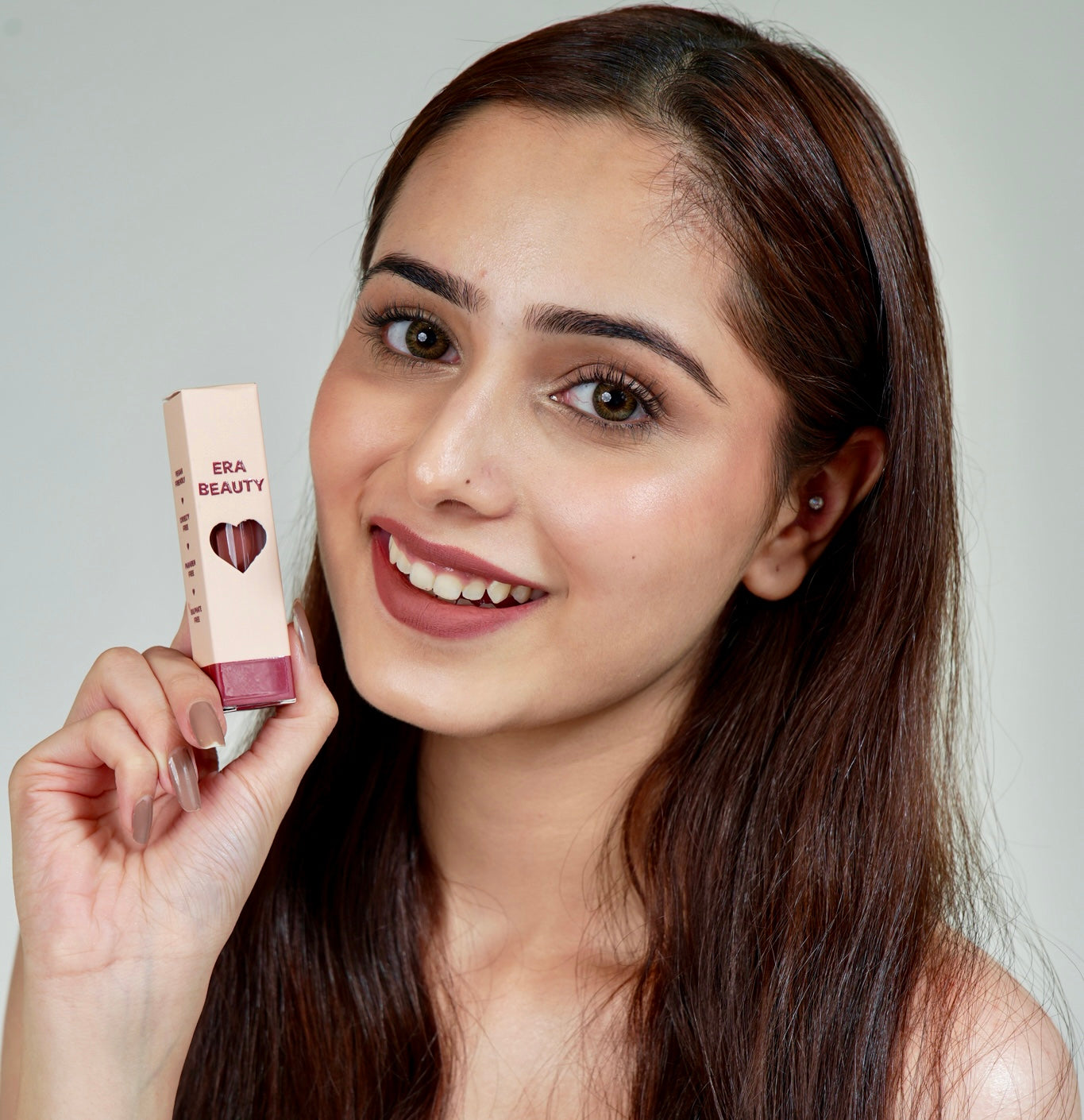 A person holds a lip product from Era Beauty.