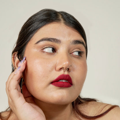 A woman face close-up with era beauty velvet liquid matte lipstick in simp shade.