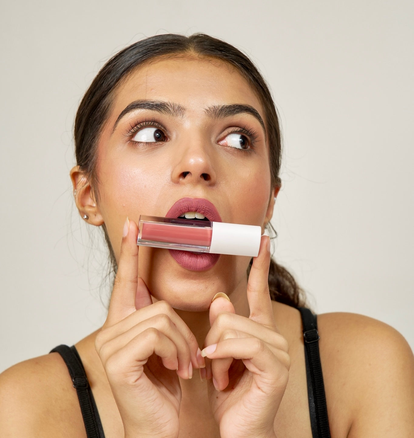 A person holds up a era beauty matte lipstick.