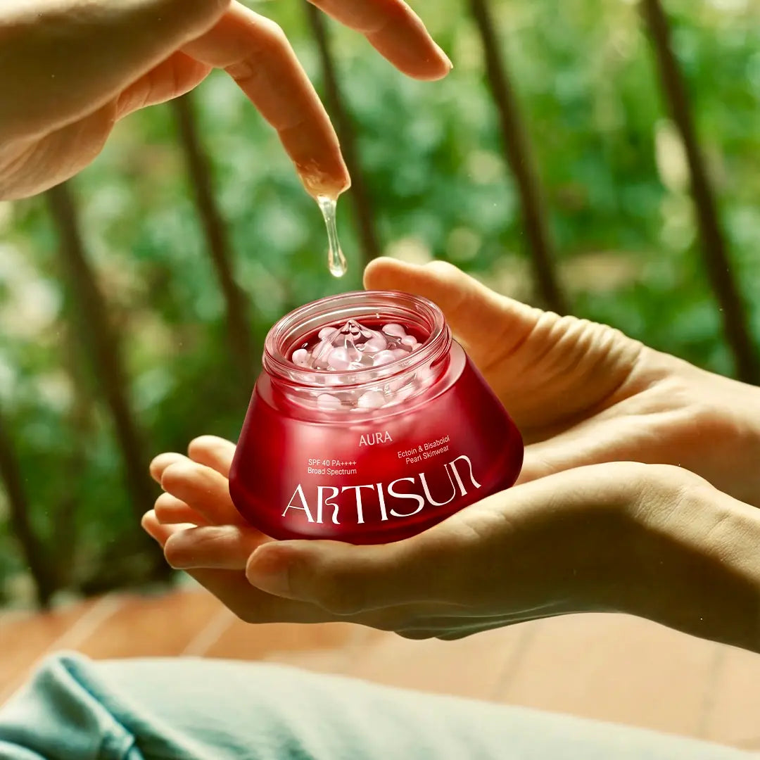 artisun Aura Pearl Skinwear Sunscreen SPF 40 box held in hand with a pearl