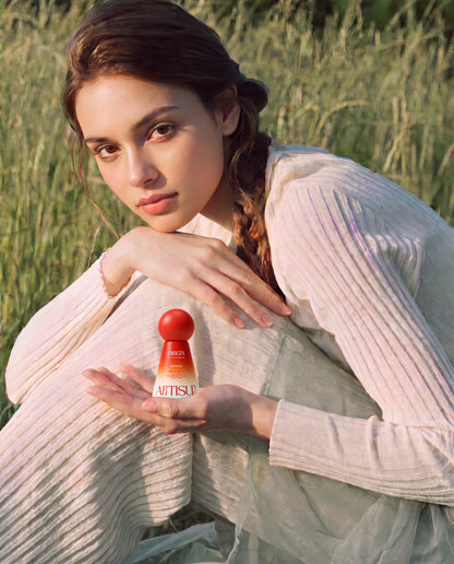 Artisun Origin 4-in-1 Milk Emulsion Sunscreen SPF 50+ held by a seated woman