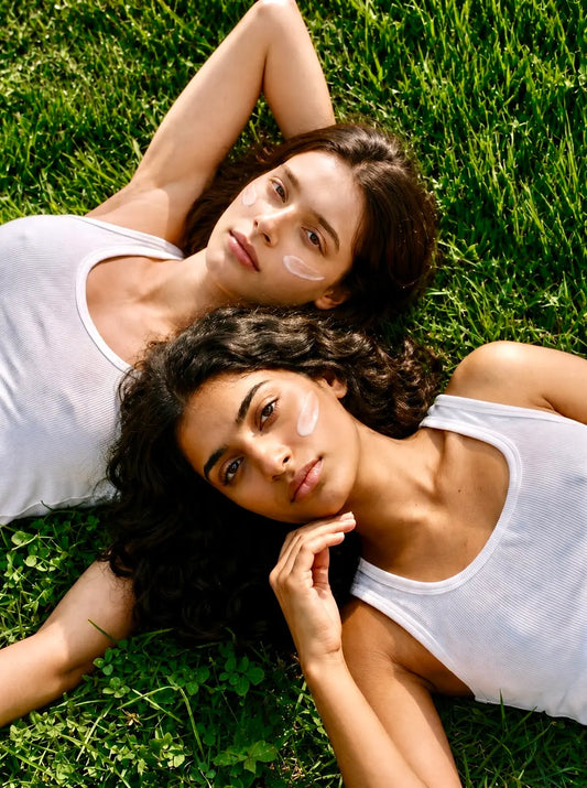 Artisun Origin 4-in-1 Milk Emulsion Sunscreen SPF 50+ worn by two girls lying on grass