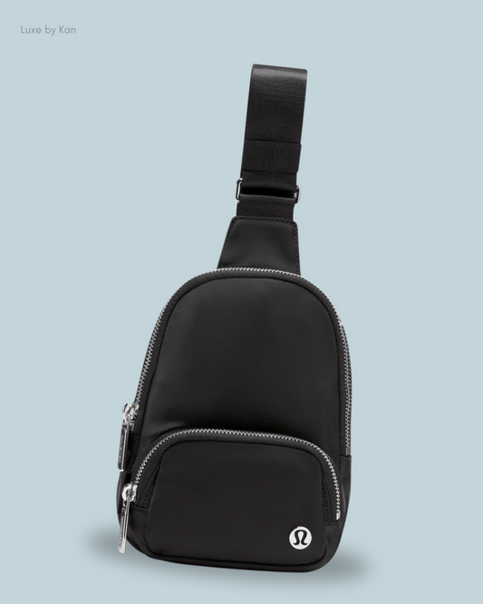 A sleek black Lululemon Everywhere Small Sling Bag with silver zippers, an adjustable strap, and a prominent logo.
