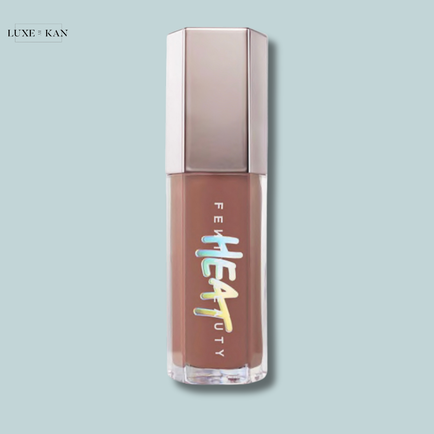 Fenty Beauty Gloss Bomb Heat lip gloss with a taupe cap and clear packaging on a light blue background.