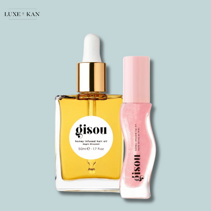 Gisou honey-infused hair oil in a glass bottle next to a pink lip oil.