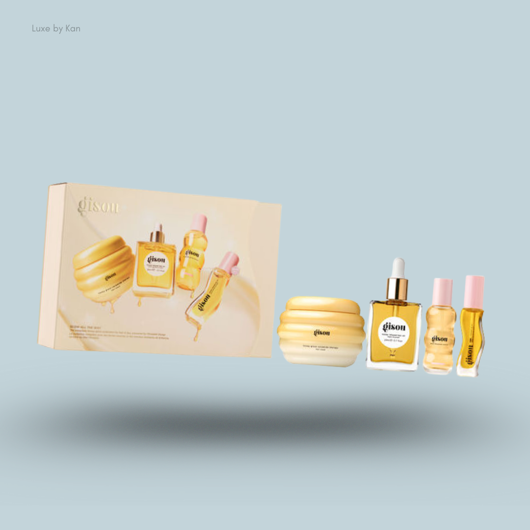 A Gisou honey infused hair care gift set with a box and four travel-sized products floating over a soft blue background.
