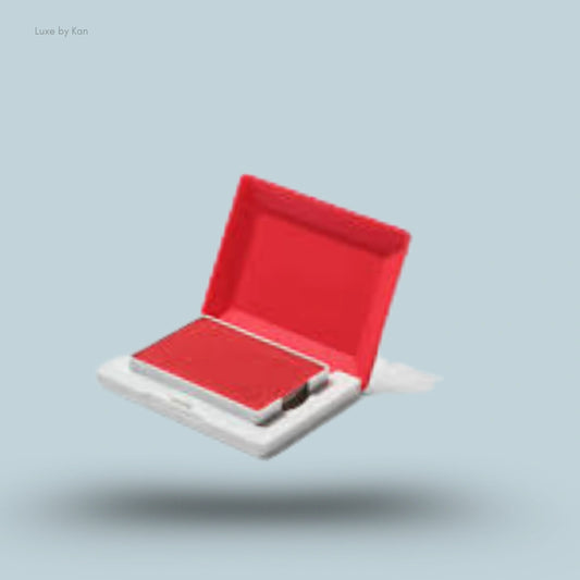 An open square Glossier Cloud Paint Plush Blush compact in a bright red shade, floating on a pale blue background.