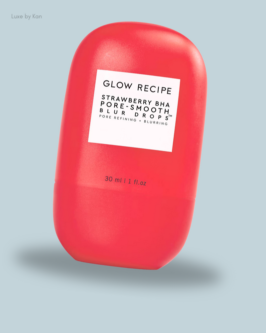 Bright red bottle labeled "Glow Recipe Strawberry BHA Pore-Smooth Blur Drops" on a light blue background. 30 ml / 1 fl. oz.
