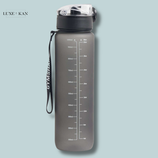 Gymshark frosted-finish sports bottle with measurements in milliliters and ounces and a black carry strap.