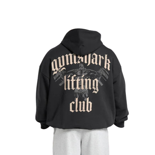 A black hoodie with "Gymshark Lifting Club" printed in bold beige letters and a weightlifter graphic on the back.