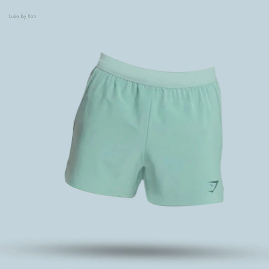 Gymshark men’s Apex Run 4-inch shorts in light-green fabric. The shorts feature an elastic waistband and a dark-green logo at the bottom of the left leg.
