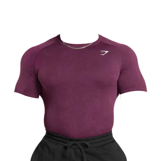 Gymshark maroon Geo Seamless T-Shirt with a slim fit and short sleeves, featuring a small white logo, paired with black sweatpants. Head and arms not visible.
