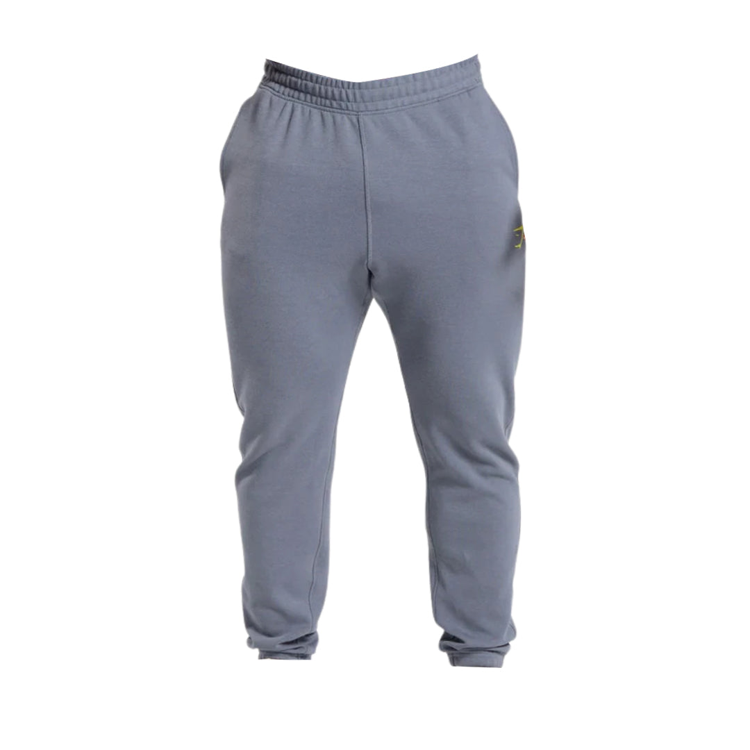 Gymshark gray impact joggers slim fits with an elastic waistband and a yellow logo detail on the side, suitable for casual wear or exercise.