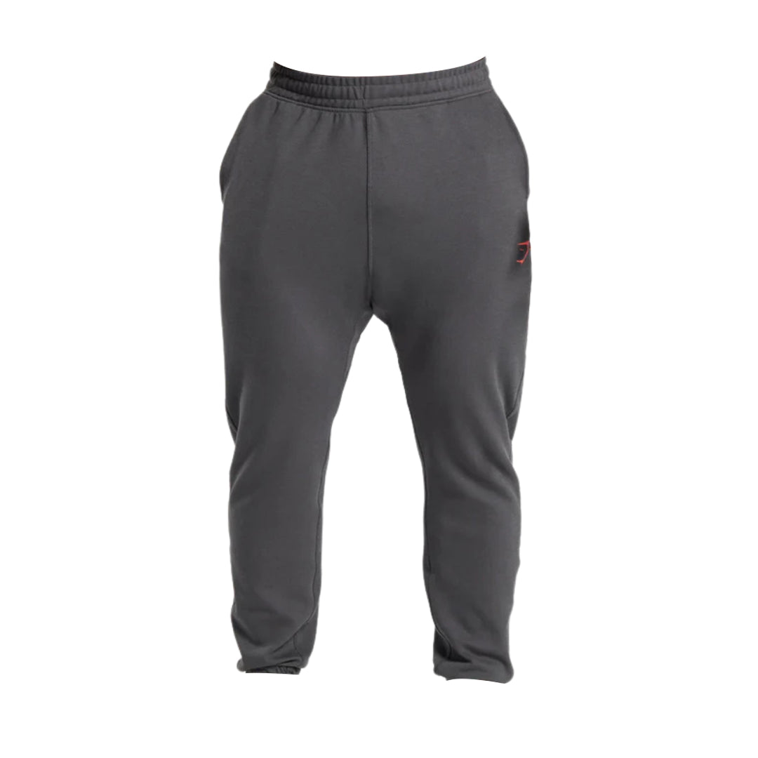 Gray joggers with an elastic waistband and a subtle logo detail in red on the front, designed for comfort and casual wear.